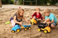 Kipplaster mit Kindern im Sand