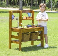 Kind stehet neben Outdoor Spielküche