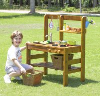 Kind kniet neben Spielküche